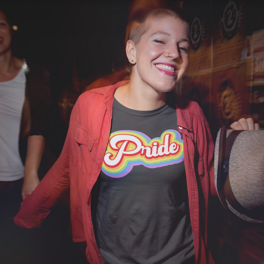 An individual confidently wears the Pride T-Shirt from HeadhunterGear, featuring retro-inspired lettering. The vibrant colors and classic design celebrate a sense of individuality and self-expression. This person stands proud, embodying the spirit of inclusivity and embracing their unique identity through fashion