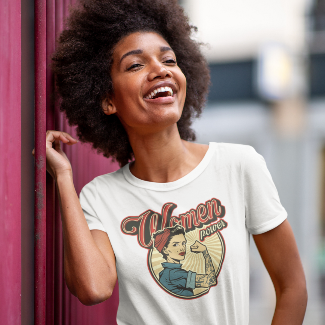 A confident woman wearing a "Woman Power" Tee from HeadhunterGear, featuring a modern take on Rosie the Riveter with cool vintage lettering. The design exudes strength and empowerment, capturing the essence of female resilience and modern style.